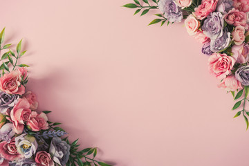 Creative arrangement of colorful flowers on pink background. Spring nature flat lay.