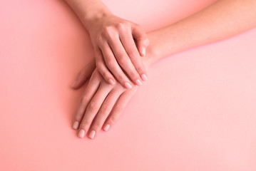 Obraz na płótnie Canvas hands with neat manicure on a pink background