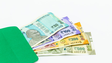 The brand new Indian currency bank notes of 50, 100, 200 and 500 rupees, New Indian Currency  in green envelope on white background, Success and got profit from business