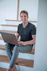 cheerful young man talking by video link using laptop