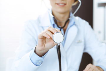 Unknown doctor woman holds stethoscope head, close-up. Physician ready to examine and help patient. Helping and insurance in health care, best treatment and medicine concept