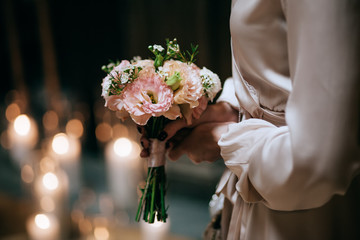 beautiful wedding bouquet with pink flowers  in hands of bride