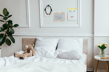 interior of empty children room with bed, teddy bear and paintings