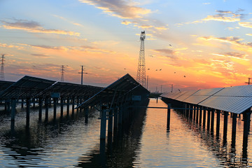 Fototapeta premium Solar photovoltaic panels in the water, in the sunset sky background