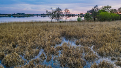 Beautiful sunset above fishing pond in farm. Countryside waterscape.