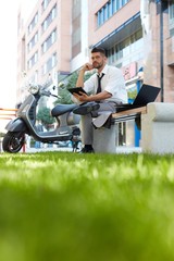 Businessman outdoors working with mobile devices