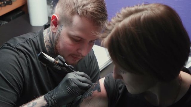 Footage of young master getting tattoo of snake in salon, process