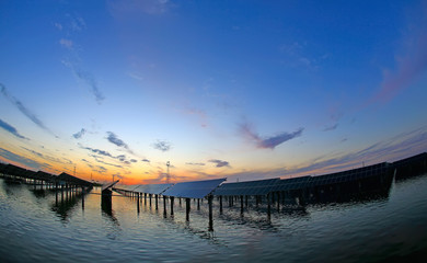 Solar photovoltaic panels in the water, in the sunset sky background