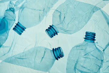 Empty plastic squashed bottles over blue background. Collecting plastic waste to recycling. Concept...