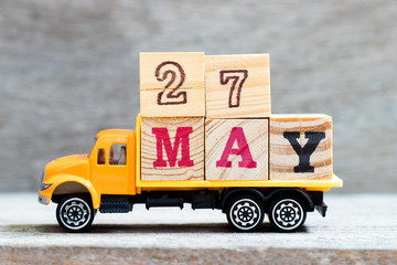 Truck hold letter block in word 27may on wood background (Concept for date 27 month May)