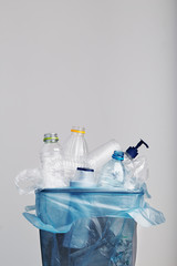 Heap of plastic bottles, cups, bags collected to recycling in a metal bin. Concept of plastic...