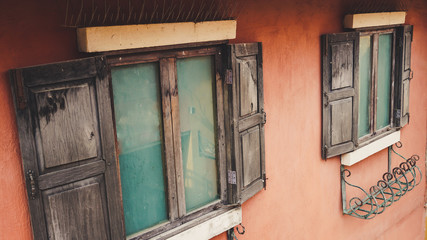 Closed rustic wooden window outside old house cement wall.	