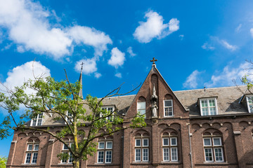 facade of historical building with sculpture and towers in Woerden, The Netherlands