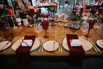 Beautiful, decorated table with flower decorations and red candles. Above view, top down. Christmas evening or wedding party decoration.