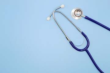 Flat lay of stethoscope for doctor checkup on light blue background with copy space, healthcare and medical concept, top view photo.