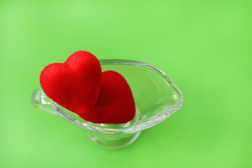 Two hearts in a transparent glass dish. Symbol of love. Romantic greeting card. Copy space - holiday concept, Valentine's Day, March 8, International Women's Day.