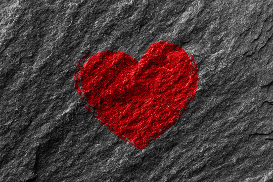 coeur rouge qui symbolise l'amour  sur un cailloux , roche 