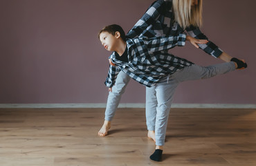 Woman doing exercises with a little son at gym. Closeup