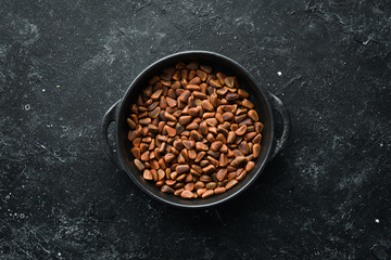 Cedar nuts in the shell, in a bowl. free space for your text. Top view.