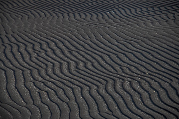 Lines in a black sand beach