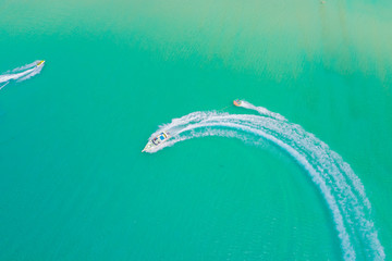 Aerial drone photo of extreme powerboat donut water-sports cruising in high speed in tropical turquoise bay. Thailand, Phuket, Kata beach