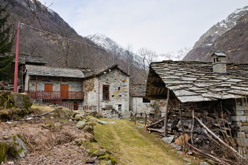 Fondo, Piedmont, Italy - January 20, 2020: old abandoned rustic mountain houses made of local stone in the ancient village of Fondo, in a winter morning
