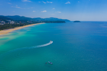 Aerial drone photo of extreme powerboat donut water-sports cruising in high speed in tropical turquoise bay. Thailand, Phuket, Kata beach