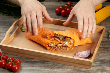 meat in pita bread with salad on a wooden tray cherry tomatoes