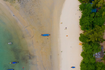 Aerial view or top view of long-tailed boat is floating on the emerald sea. Calm andaman sea at...