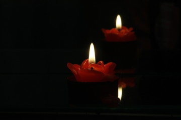 Candle flame light at night and reflection effect of the mirror with abstract black background