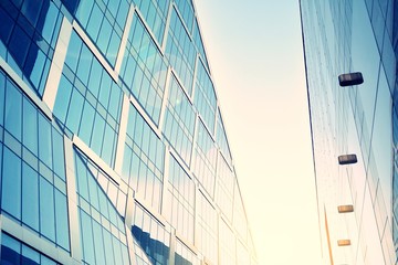 Modern office building facade abstract fragment, shiny windows in steel structure. Architecture with sun ray. Retro stylized colorful tonal filter effect.