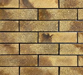 Textured brick in beige with black seams from decorative tiles for wall decoration. Artificial stone. Background, texture