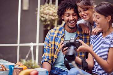 group of young friends looking to camera and talking about photos and photography outdoor