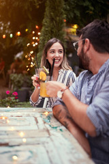 cheerful young couple  with cocktails  having fun in nightclub celebrating. Fun, love, valentine’s day  concept.