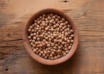 chickpeas in a brown clay pot, top view.