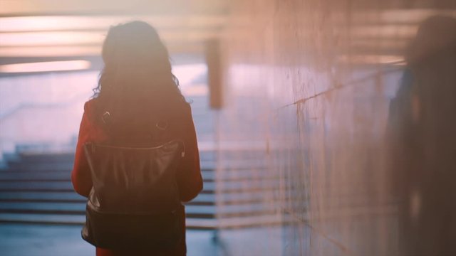 lonely adult curly female walking in subway