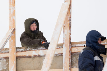 Two workers in overalls at a construction site