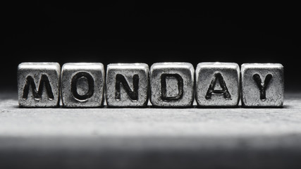 Volumetric inscription monday silver metal cubes on a dark black background. Deadline calendar, personal scheduling and time management, seven days a week