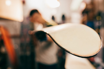 selective focus of worker holding snowboard in repair shop