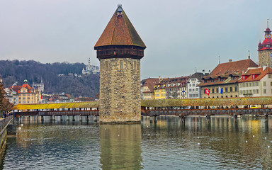 Famous wooden Chapel Bridge in Lucerne in Switzerland. Subsequently restored, the Kapellbrucke is the oldest wooden covered bridge in Europe, as well as the worlds oldest surviving truss bridge