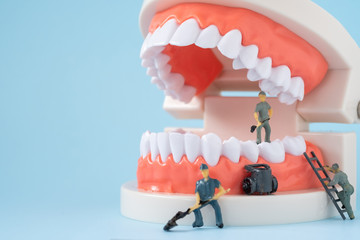 Miniature people of the teeth cleaning workers are medical and health care concepts.