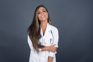 Lovely good-natured young doctor caucasian woman having charming smile and friendly expression holding herself wanting to show her love and sympathy. My heart is for you!