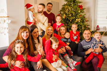 Large family posing on sofa near Christmas tree