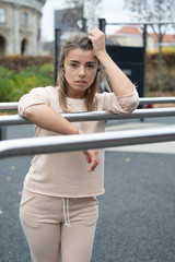 Young fitness woman make stretching, doing morning exercise, warm-up body before marathon, standing on the sport ground. Sport, urban fitness and workout concept.