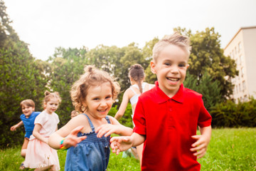 Children run and play on a meadow on a children's birthday party