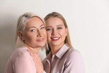 Mother and her adult daughter on white background