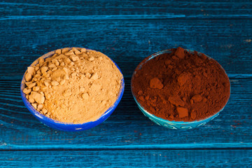 Organic carob and cacao powder in bowls. Natural cocoa substitute.