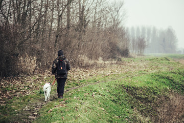 Girl and her dog walking in a rural scene