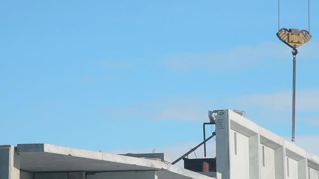 Crane hook over building under construction