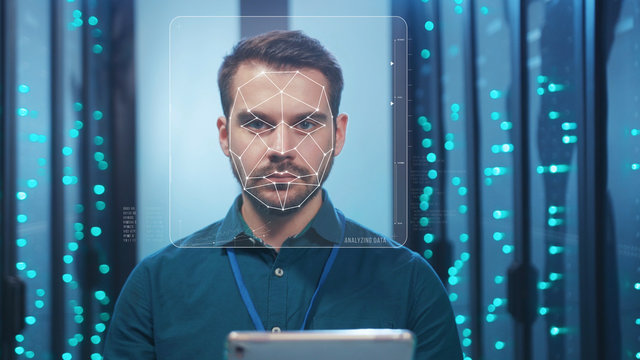 Future. Face Detection. Biometric Facial Recognition. ID Information Security. 3D Scanning Of Face Of Caucasian Server Engineer Working With Tablet At Data Center. Data Analyzing Animation With Points